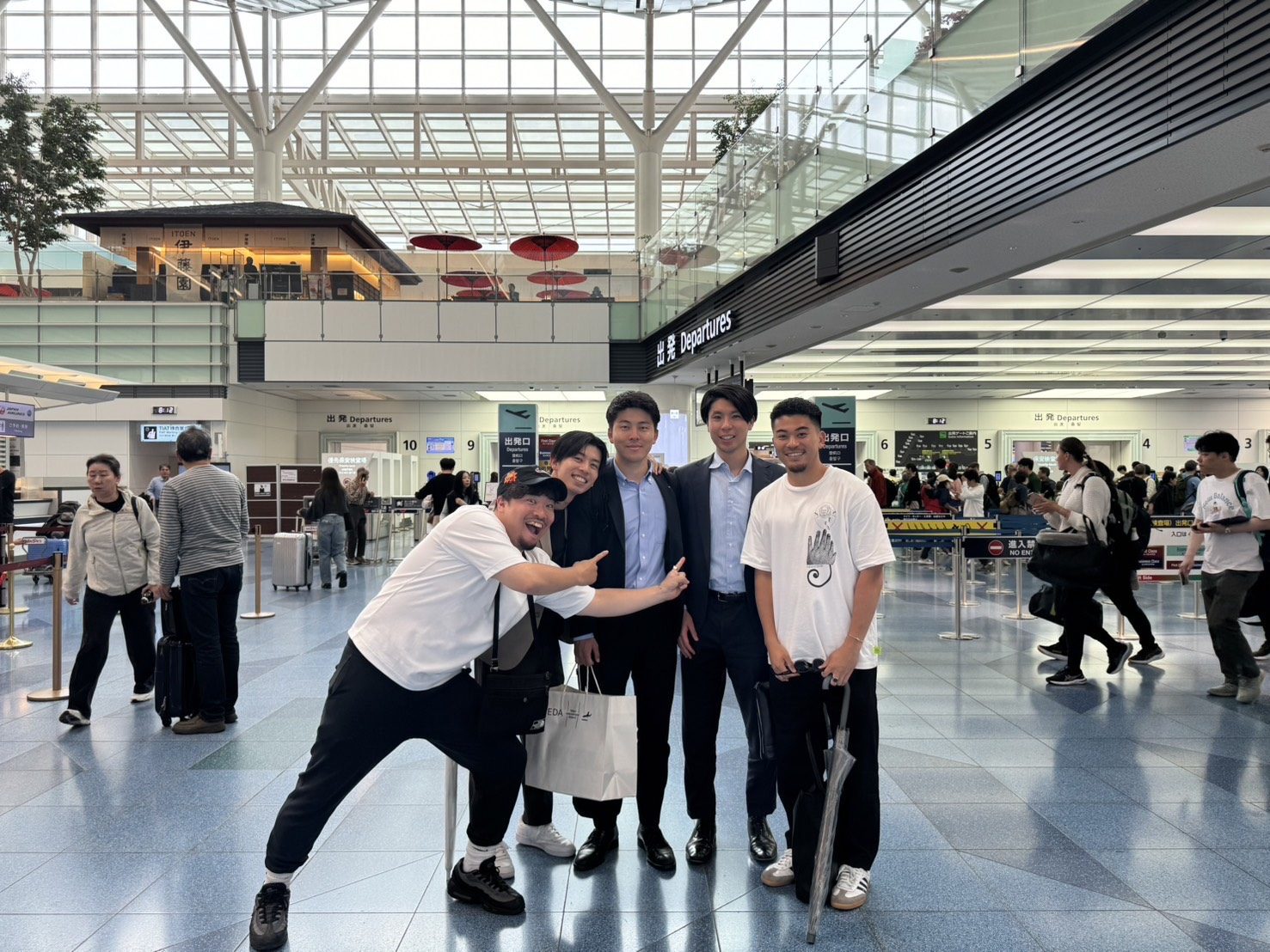 空港の出発ロビーに立つ5人